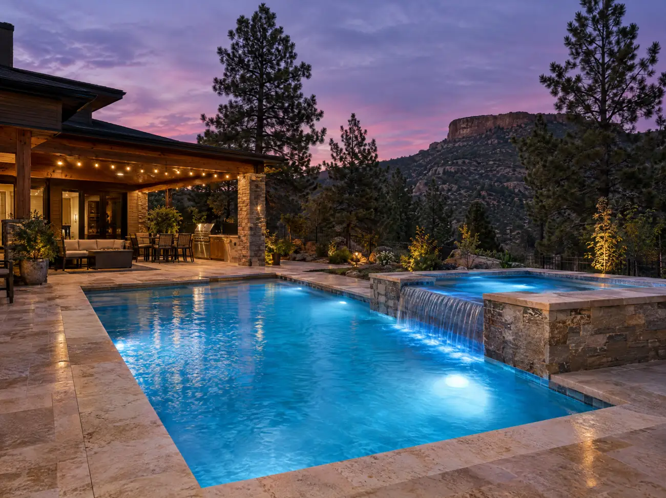 Castle Rock pools: a lit backyard pool and spa at dusk