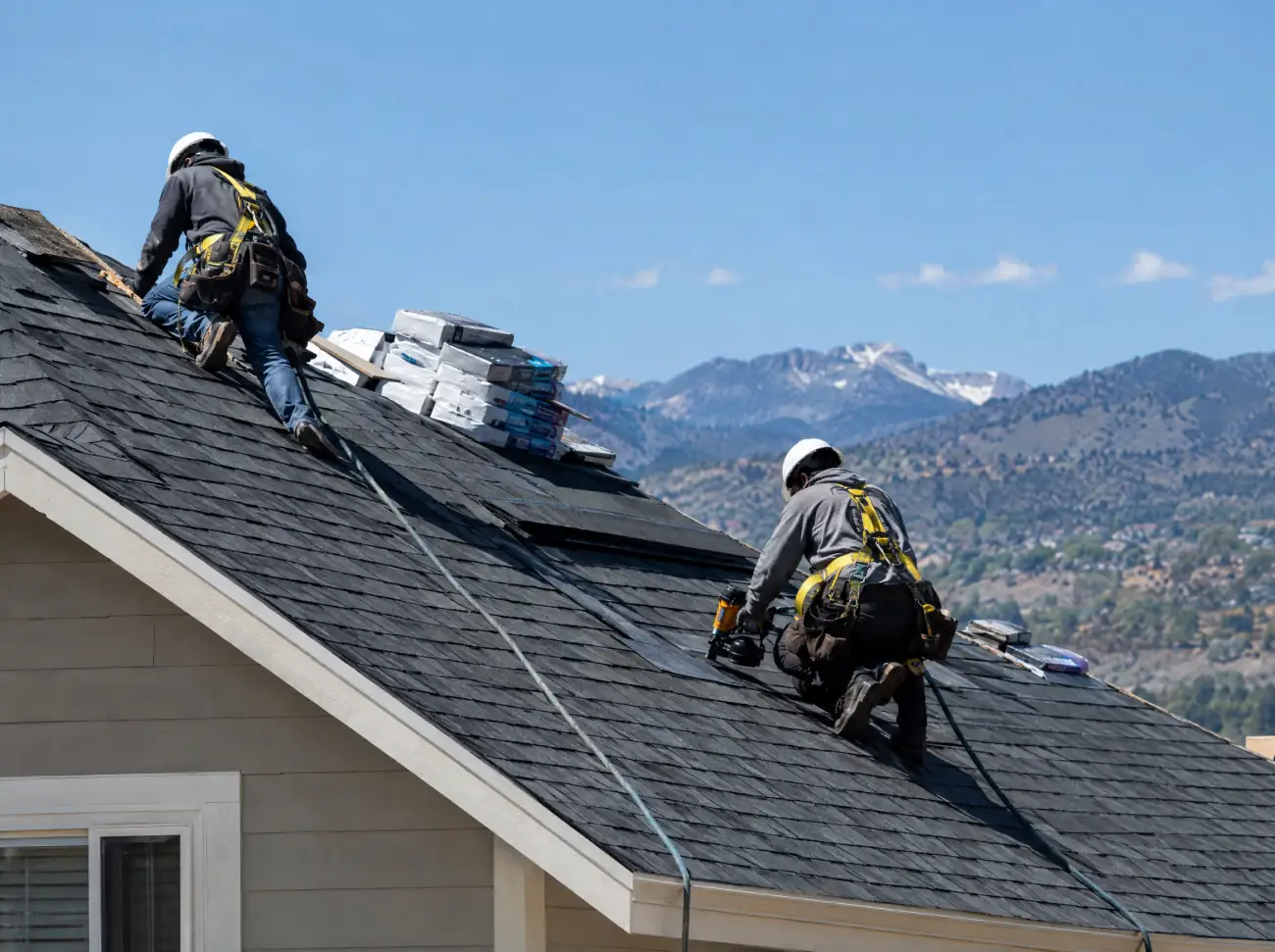 Castle Rock roofing: roofers in safety harnesses installing asphalt shingles